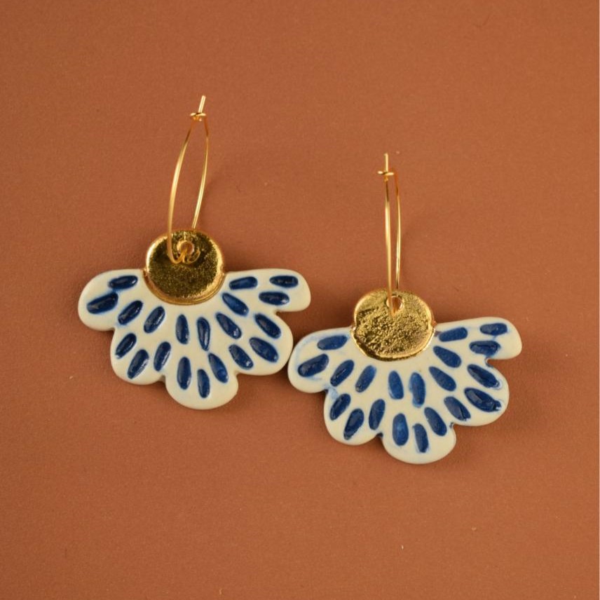 Aros con pétalos de flor, blancos con detalles en azul cobalto y oro.